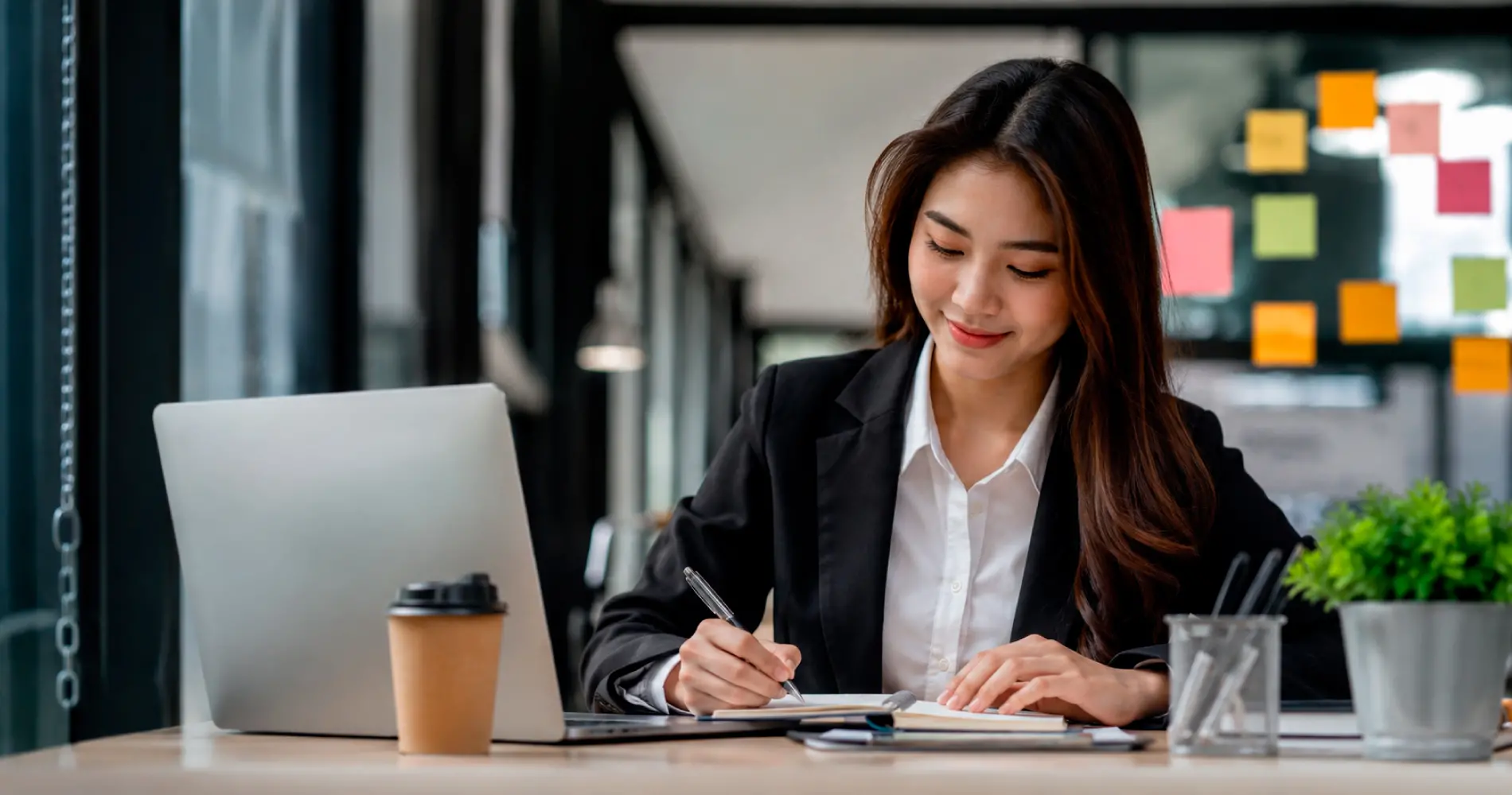 Fresh graduate working at a desk, showing communication and digital skills in a modern workplace.
