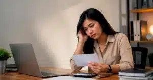 Karyawan baru terlihat ragu meninjau surat penawaran kerja karena belum berani menegosiasikan gaji yang diterima.