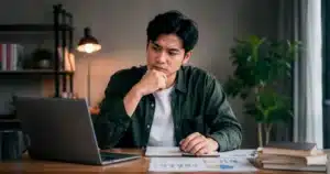 A young professional reviews notes and career plans, deciding between upskilling and reskilling for future career growth.